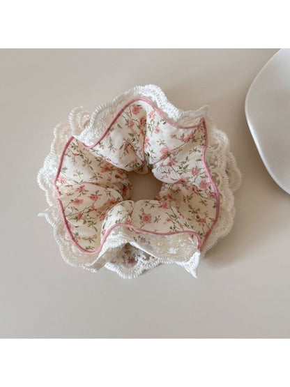 Gifty scrunchie showing pink and green floral pattern with delicate white lace edging