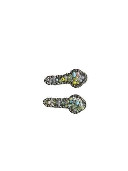 Side view of Beau key shaped hair clip securing hair with a smooth gold surface