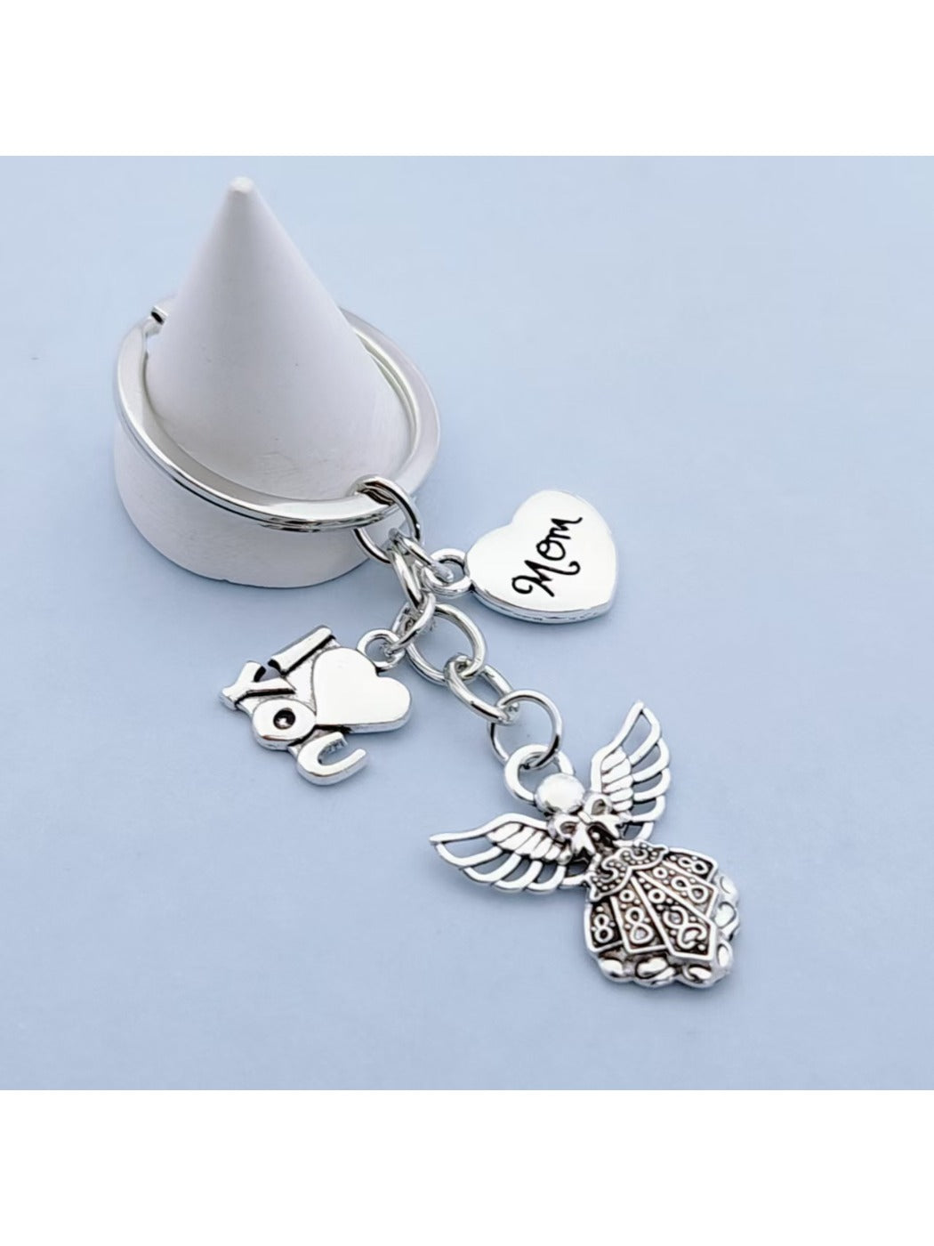 Alloy angel keychain placed next to a notebook and pen on a desk