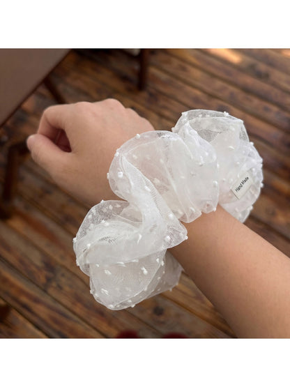 Close-up of white polka dot tulle scrunchie showing fabric texture