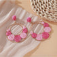 Sweet Raffia Circle Stud Earrings photographed with green plant background