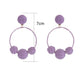 Earedge raffia round ball earrings hanging on a white display stand