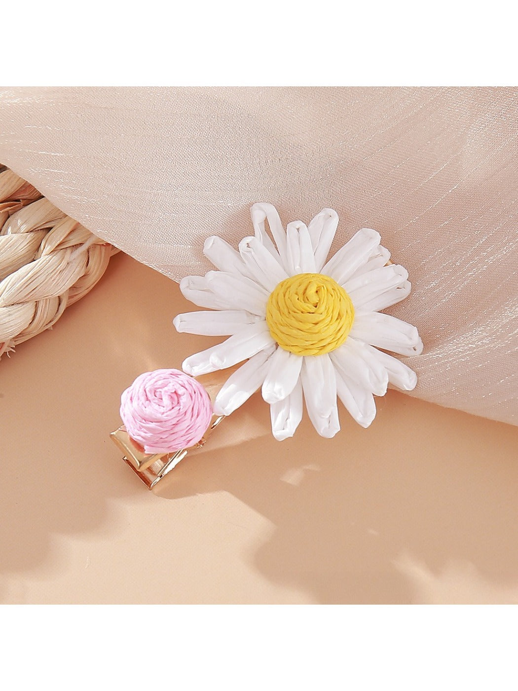 Beau raffia strawberry flower hair clip shown from above on a neutral background