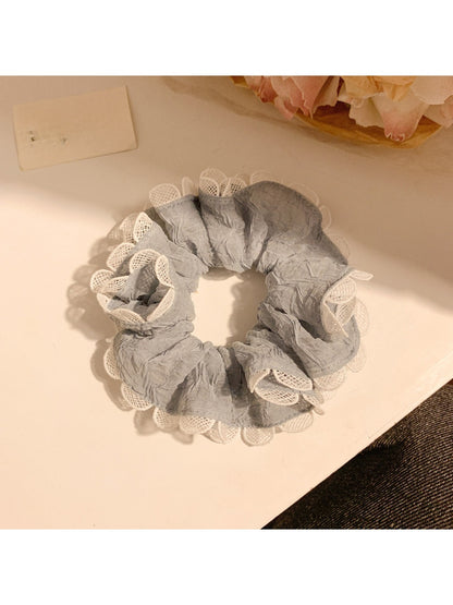 Gray ruffle scrunchie displayed flat with soft folds and gathered fabric