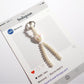 Keypus bow keychain with pink and white beads displayed against a pastel background