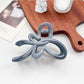 Back view of Beau ombre heart shaped bow claw clip showing clip teeth and hinge