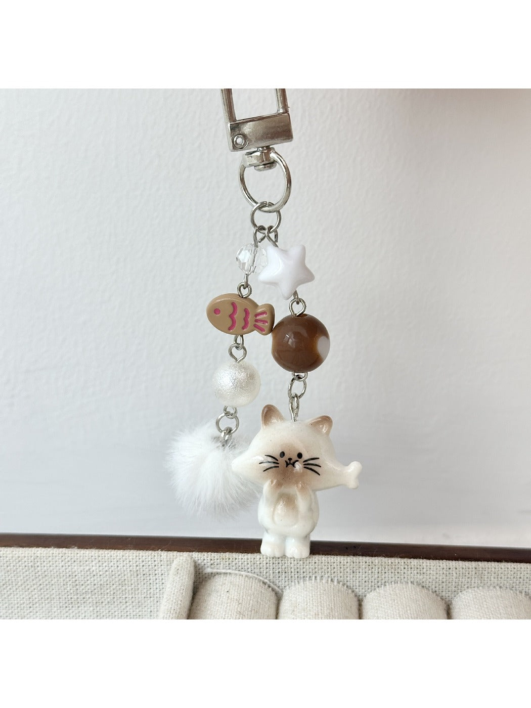 Cat keychain held in hand showing size and lightweight design