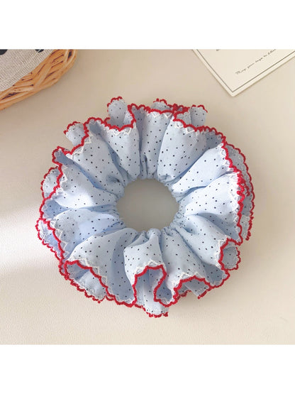 Gifty scrunchie displayed alongside matching hair accessories on a wooden surface