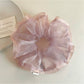 Pink ruffled scrunchie styled on a wrist as a fashion accessory