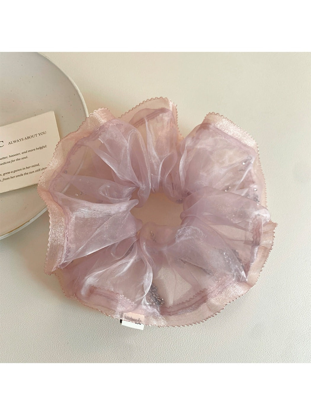 Pink ruffled scrunchie styled on a wrist as a fashion accessory