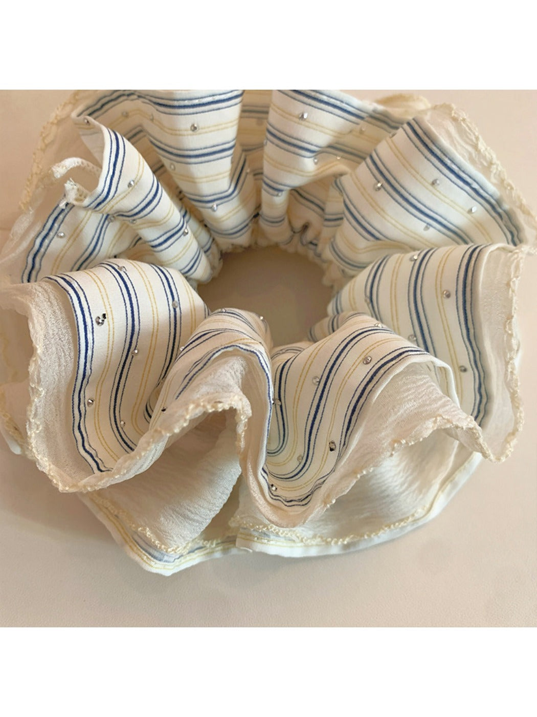 Flat lay of Gifty minimalist scrunchie with subtle stripes on a wooden surface