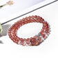 Close-up of strawberry quartz beads on Lovra multi-wrap bracelet with silver detailing