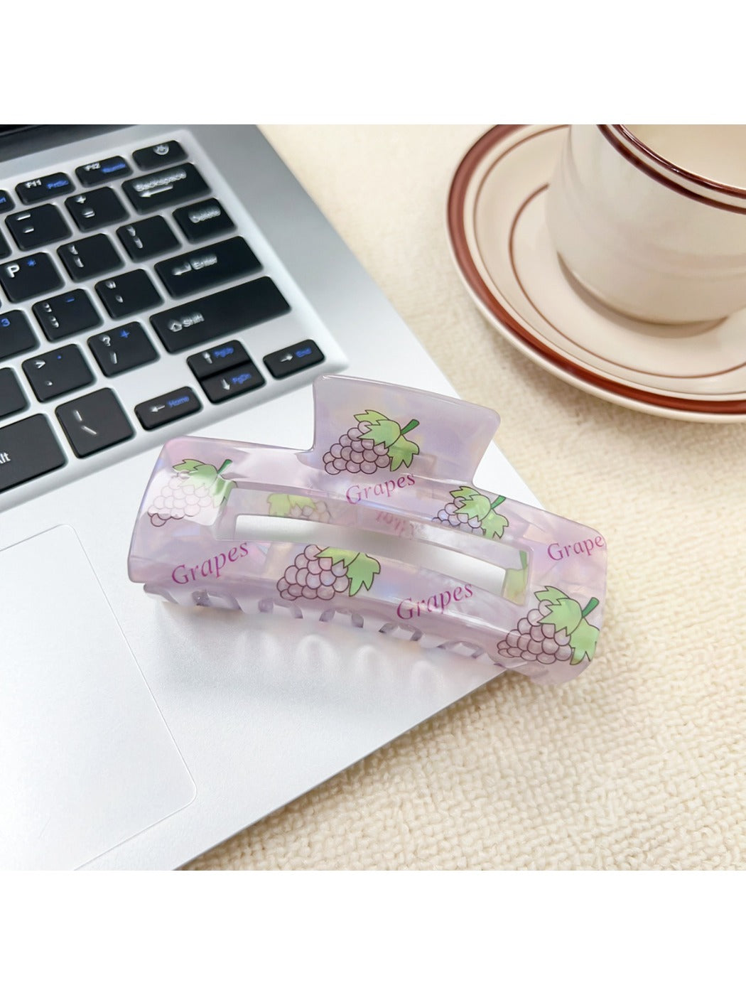 Beau claw clip resting on a fabric surface highlighting the vibrant fruit pattern