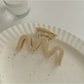 Beau vintage wave line claw clip displayed on a wooden surface
