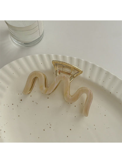 Beau vintage wave line claw clip displayed on a wooden surface