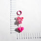 Hand holding Keypus bow heart beaded keychain showing its size and details