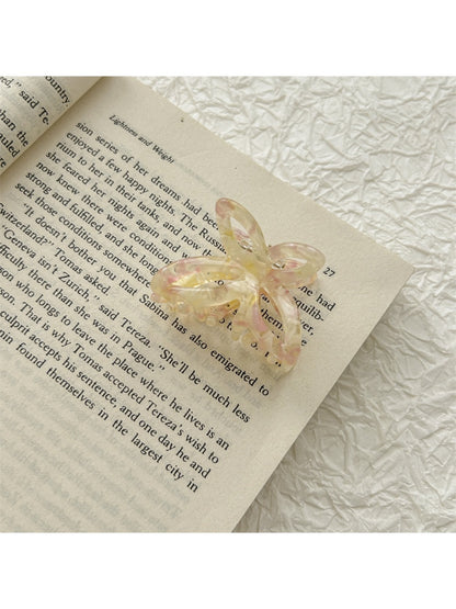 Beau acetate butterfly shaped claw clip positioned to highlight butterfly wings design