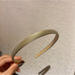 Candy color satin headband in pastel green on white background