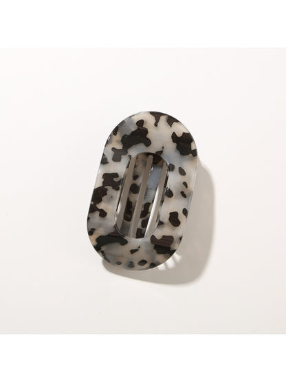 Beau hair clip resting on fabric surface to contrast colors and texture