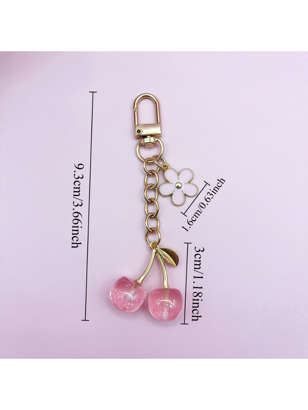 Hand holding the cherry charm keychain showing its size and design details
