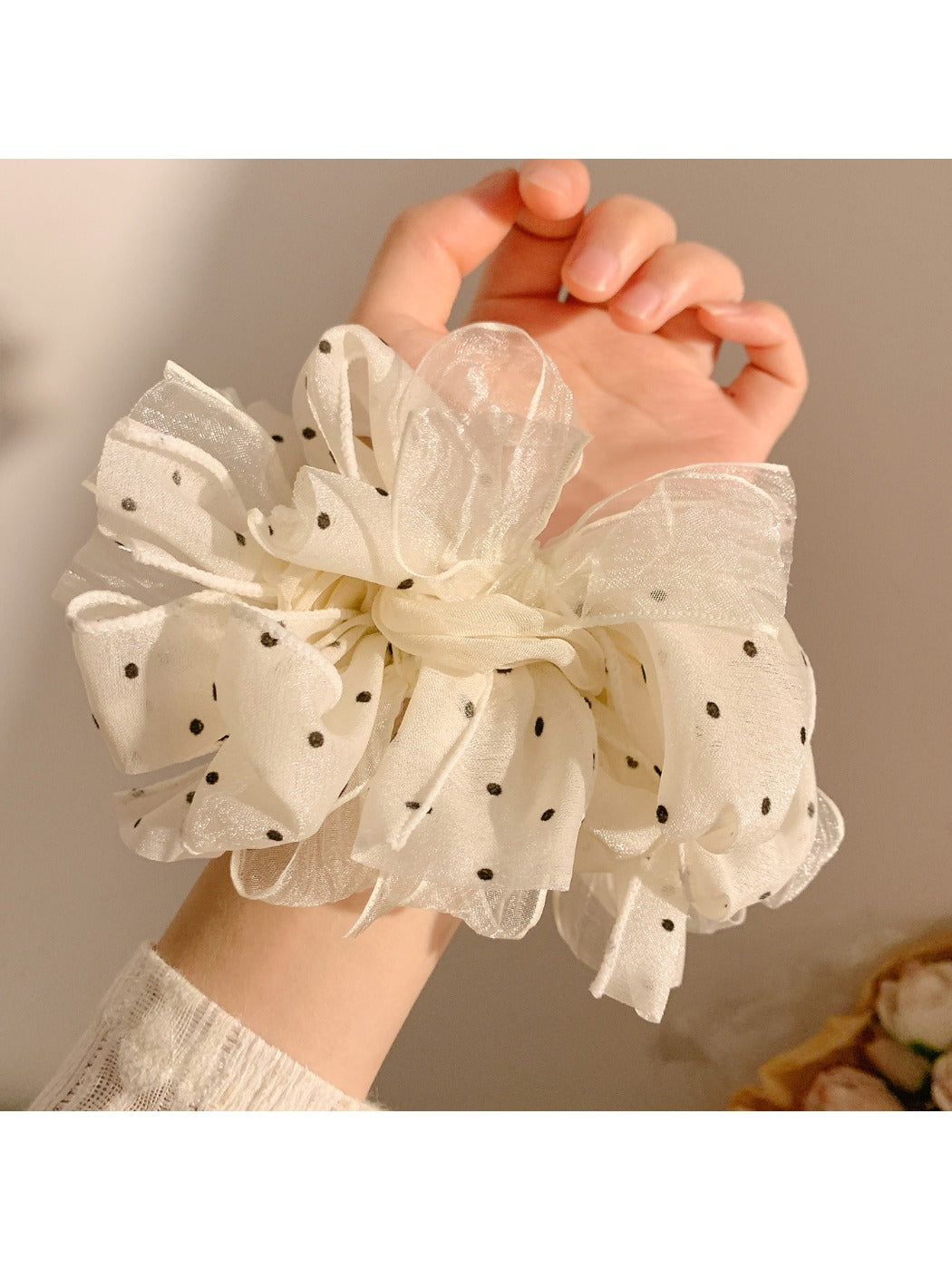 White tulle scrunchie with black polka dots styled in a ponytail