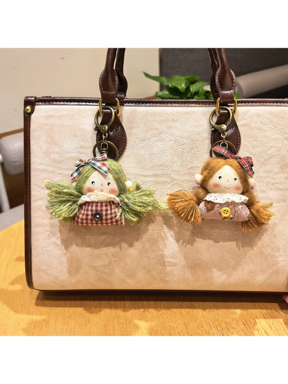Vintage girl charm keychain displayed hanging from a set of keys on a wooden surface