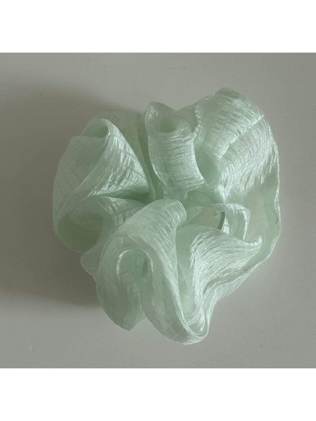 Beige tulle scrunchie styled with casual outfit on model's wrist