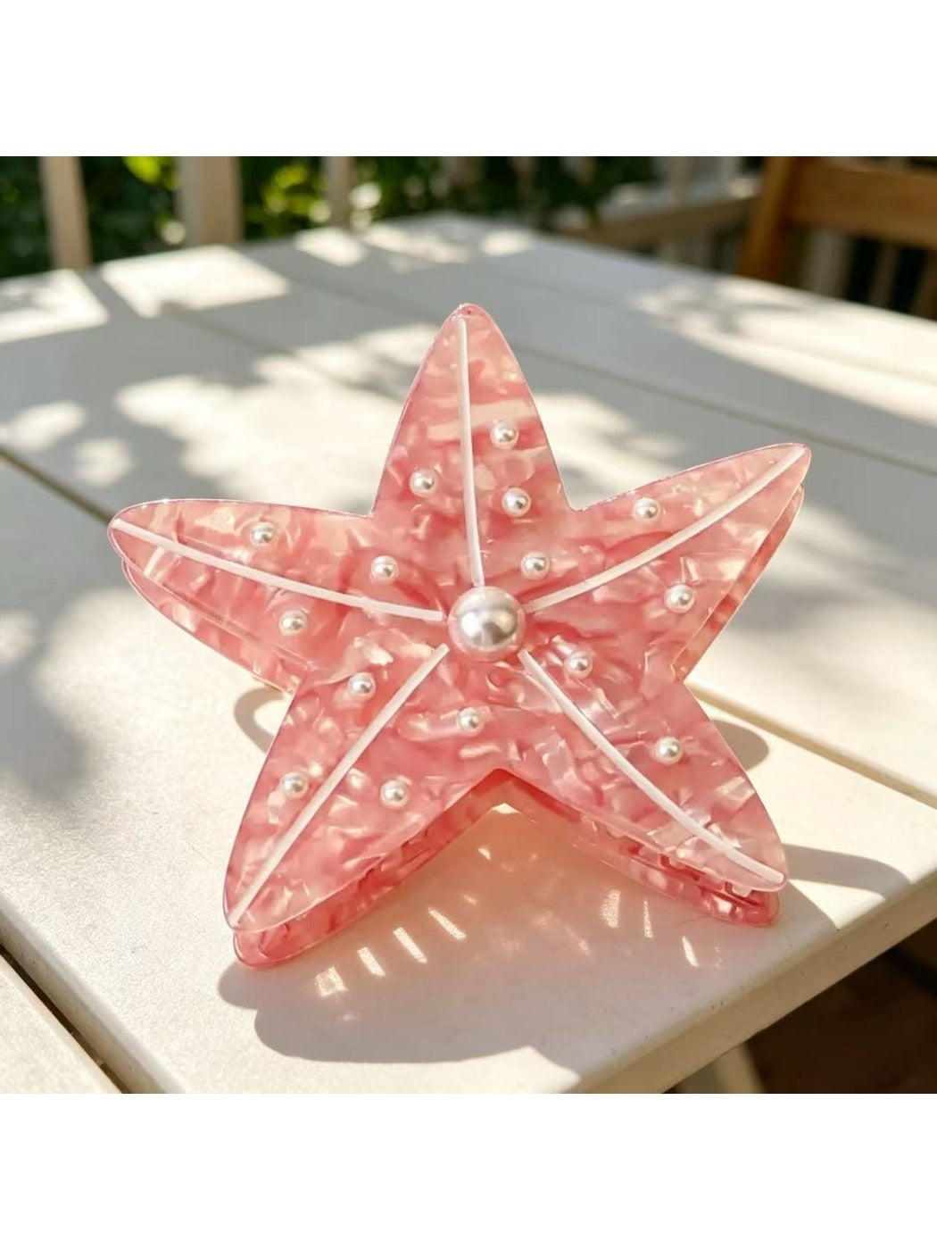 Side view of pastel pink Beau sea animal claw clip showing curved edges