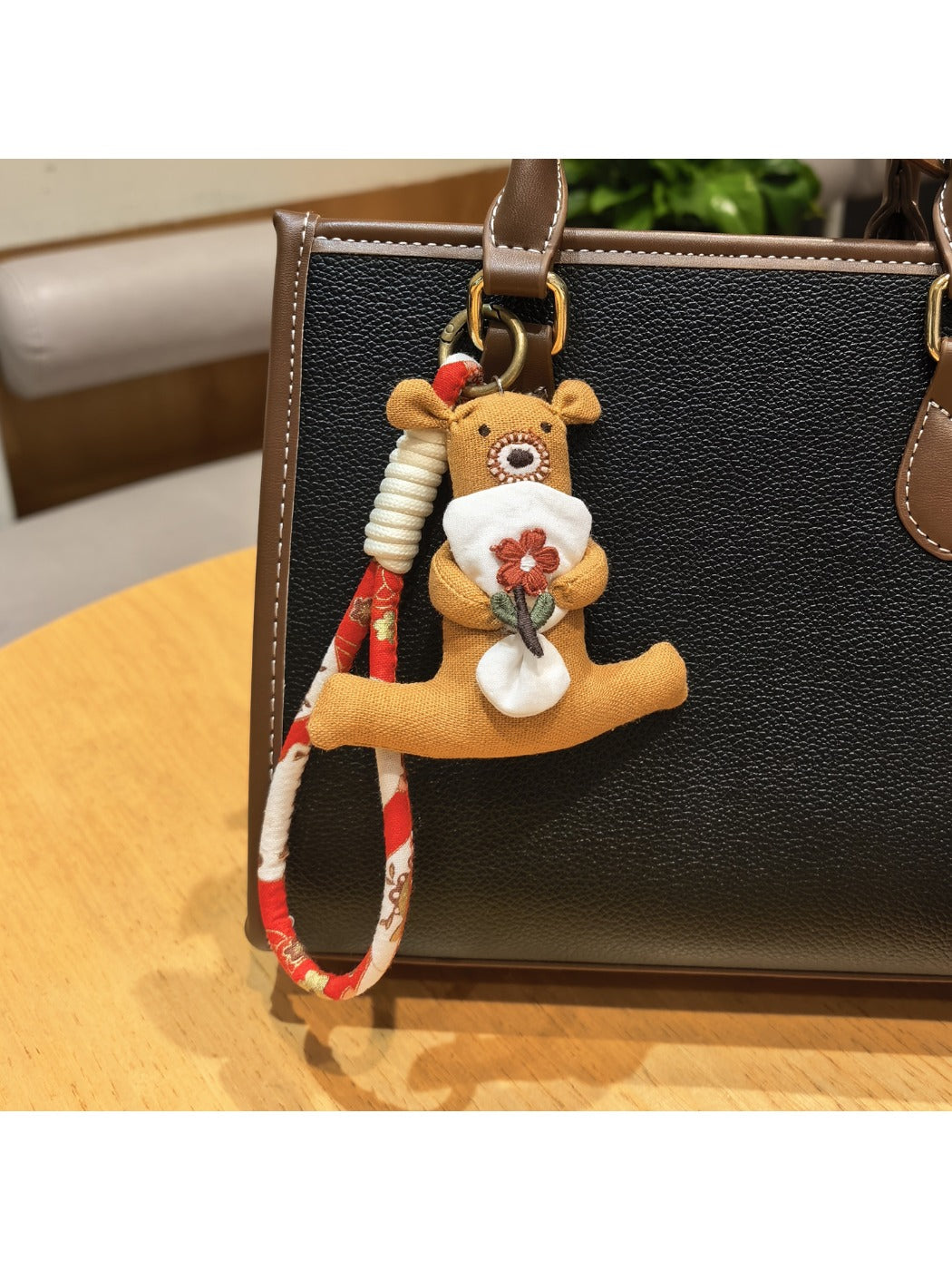 Bear keychain lying flat showing the back and flower stem