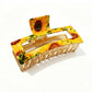 Beau rectangular hair clip with pink and white flower pattern on a beige background