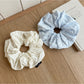Close-up of Gifty scrunchie showing detailed cutout print design