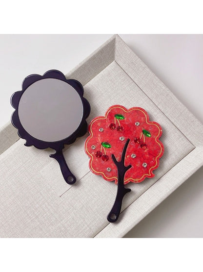 Mirroray tree-shaped handheld mirror placed on a wooden surface