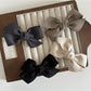 Side view of Beau solid satin bow hair clip displaying clip mechanism