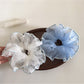 Gifty scrunchie styled in a ponytail on dark hair