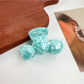 Beau hair claw clip holding thick wavy hair in a casual half-up style