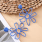 Earedge flower shaped openwork drop earrings hanging from a jewelry stand