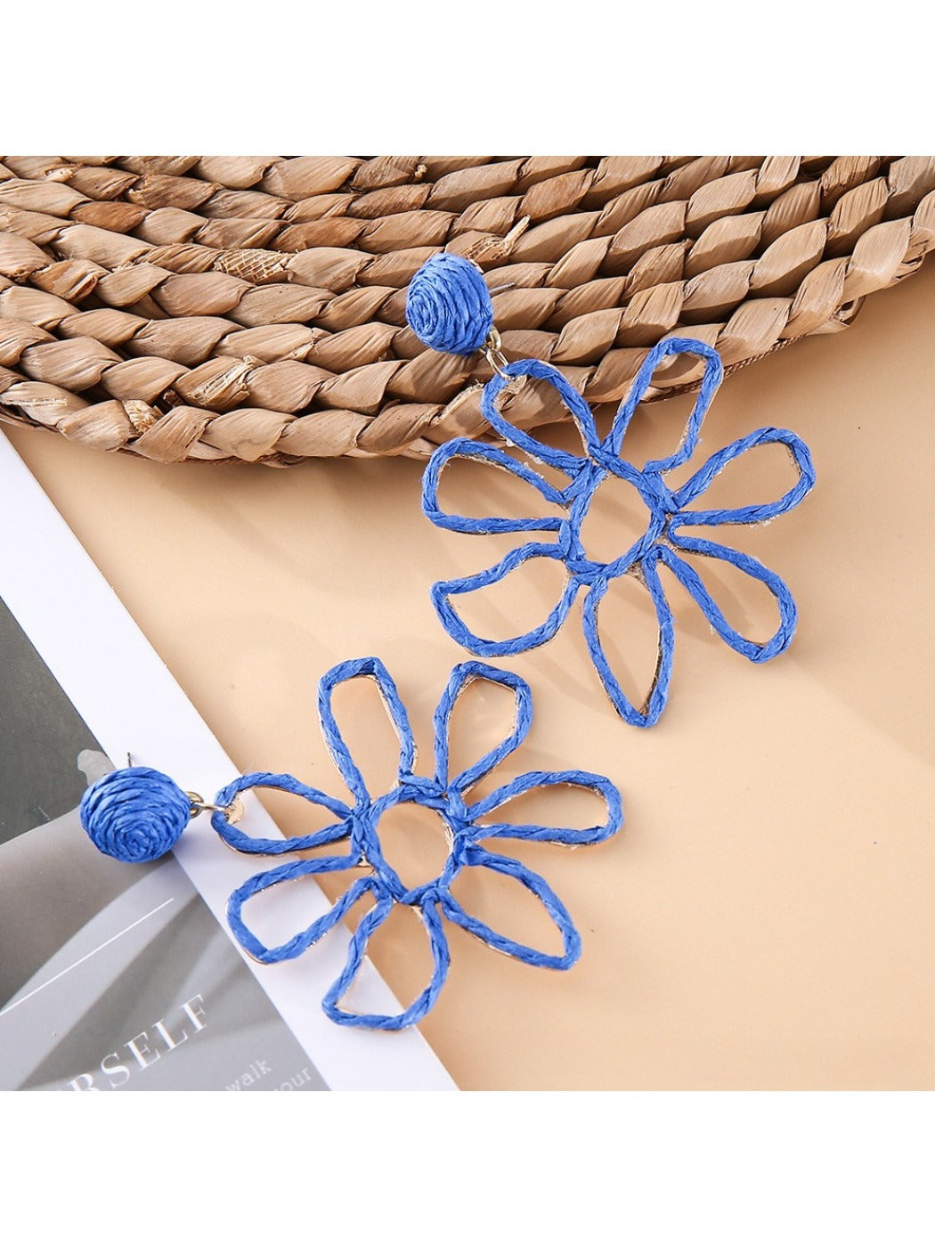 Earedge flower shaped openwork drop earrings hanging from a jewelry stand