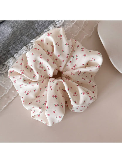 Gifty scrunchie with delicate floral pattern displayed on a wooden surface