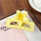 Beau square ombre flower shaped claw clip with open clasp revealing inner teeth and hinge
