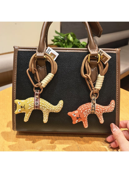 Fox charm keychain hanging from a backpack zipper pull