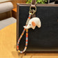 Elephant charm keychain held in a hand showing size comparison