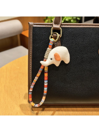 Elephant charm keychain held in a hand showing size comparison
