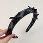Gifty plaid bow headband folded to show flexibility and material