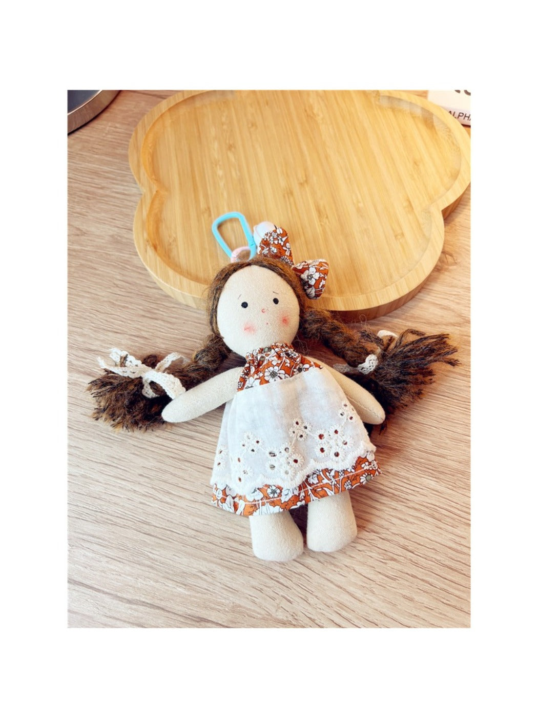 Keypus cartoon doll keychain shown with other accessories on a table