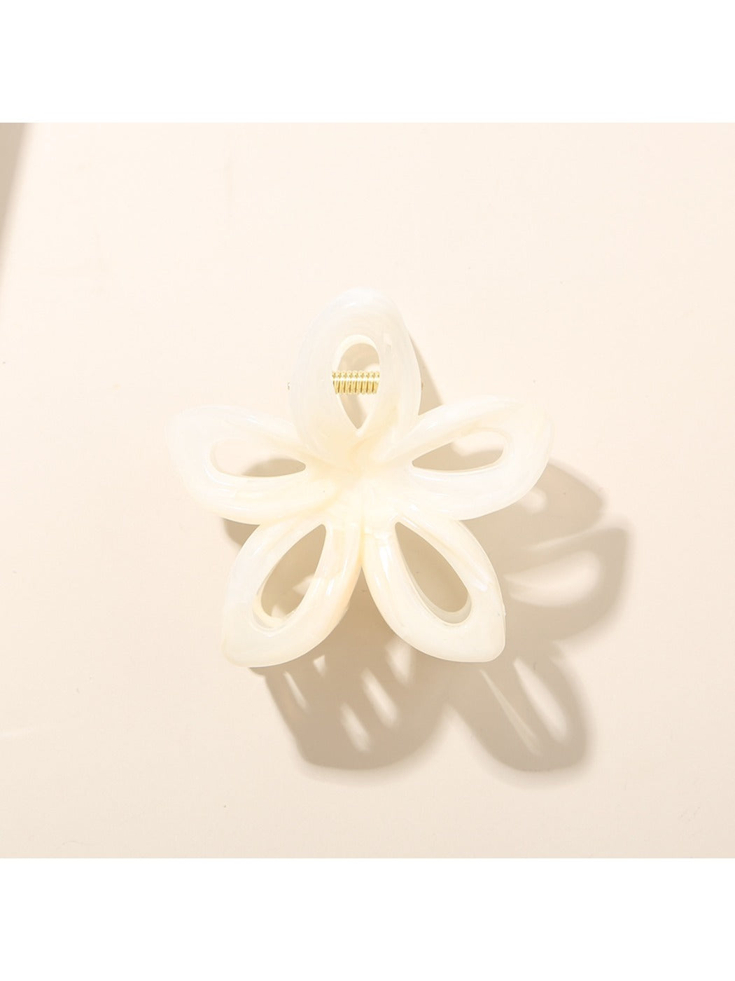 Top view of Beau openwork flower hair clip with bright, varied colors