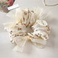 Gifty floral print bow scrunchie wrapped around a ponytail on a model