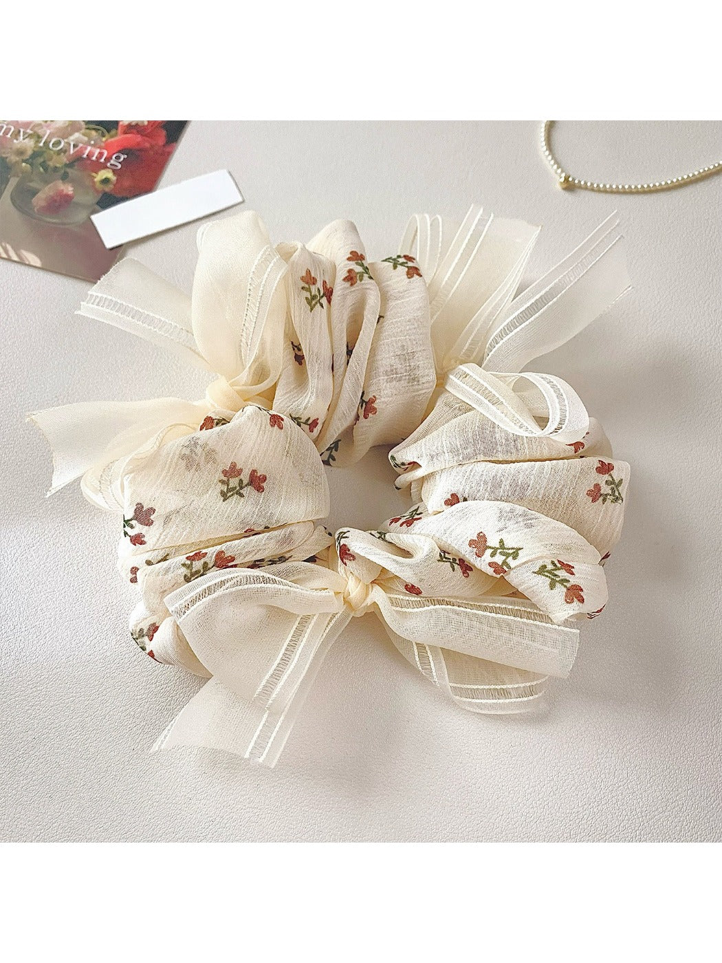 Gifty floral print bow scrunchie wrapped around a ponytail on a model