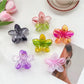 Beau colorful flower shaped claw clip with pink and yellow petals on white background