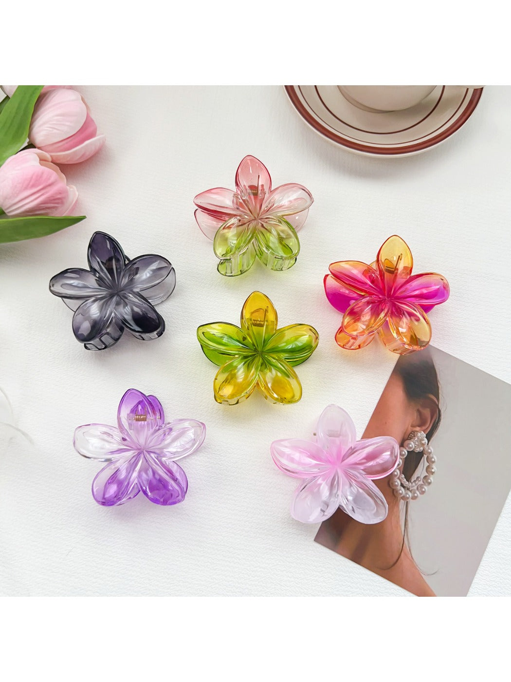Beau colorful flower shaped claw clip with pink and yellow petals on white background