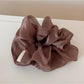 Soft romantic aesthetic scrunchie displayed with complementary accessories